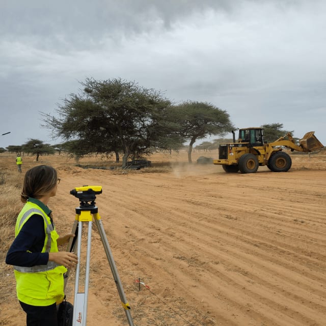 Equipe FiltrePlante supervisant les travaux de terrassement d'un système de lagunage écologique au Sénégal avec relevés topographiques